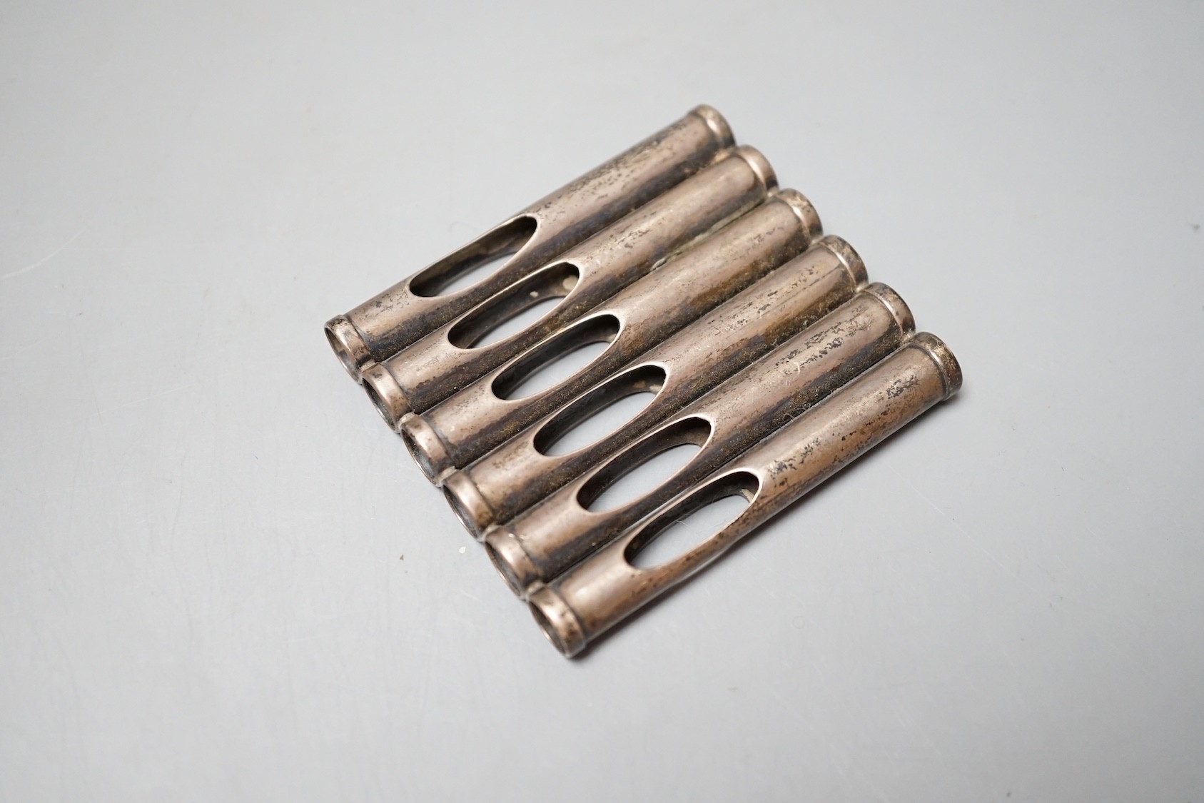 An Edwardian patent novelty cigarette holder, modelled as a magazine of bullets, William Maguires, Birmingham, 1904, 72mm.